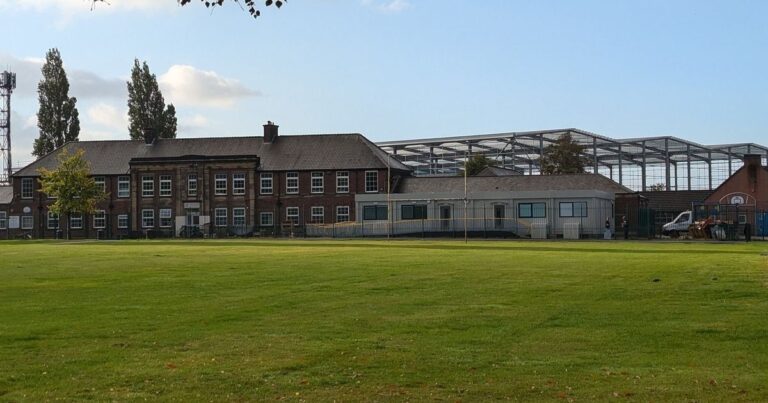 The school in the shadow of giant 'cruise ship' warehouses where children wade